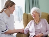 young nurse chatting with senior woman in care home